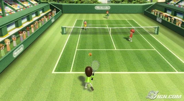 Gameplay screenshot from Wii Sports Tennis showing Mii characters mid-match on a green grass court with a crowd in the stands.